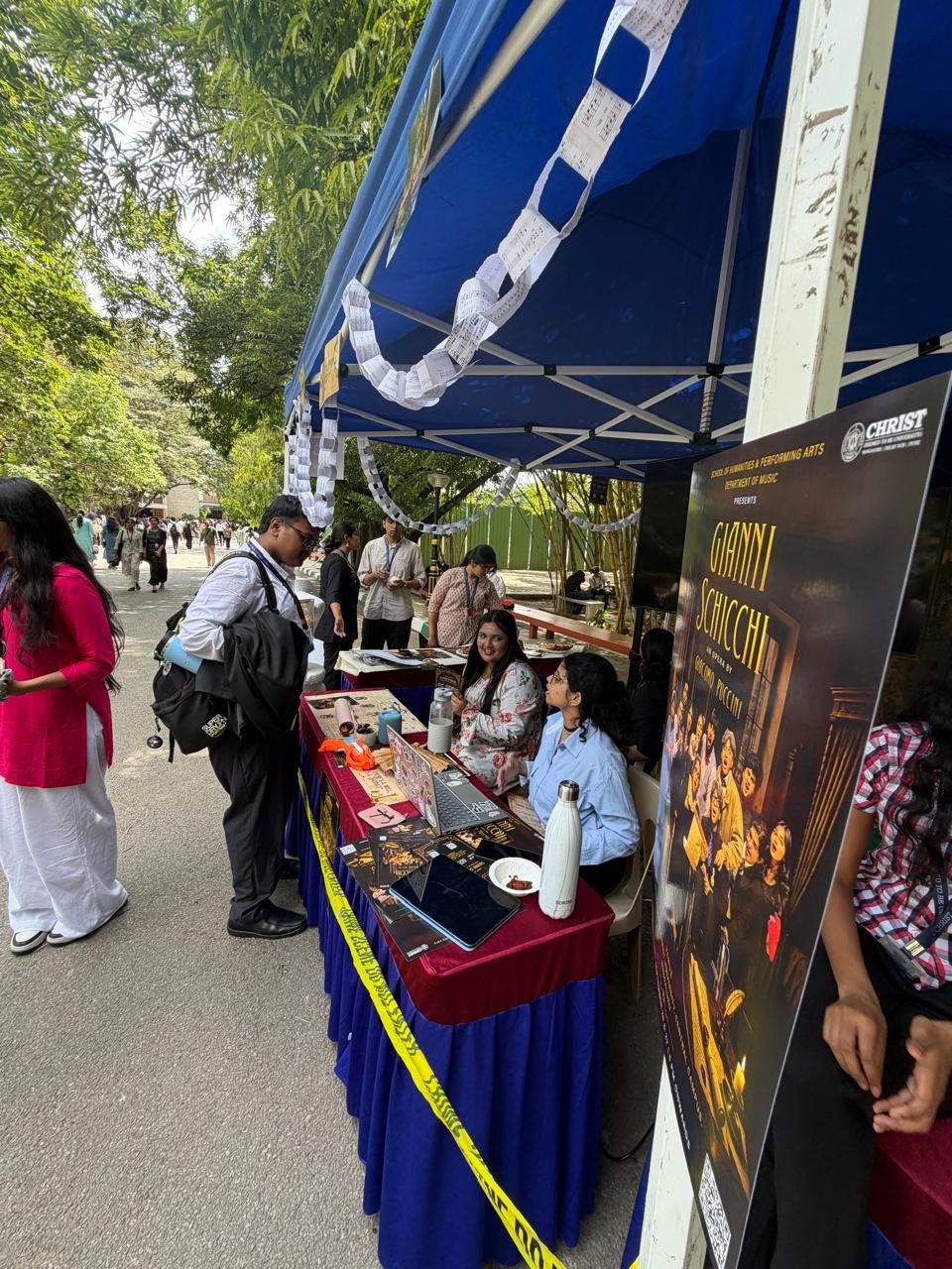 The Gianni Schicchi banner standing beside the table at the campus stand.