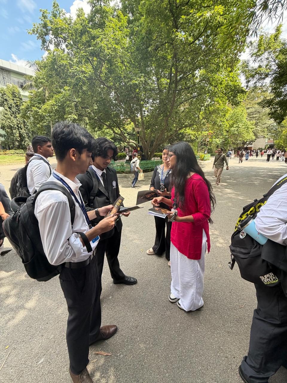 A member of the team handing out information about the opera along the campus path.